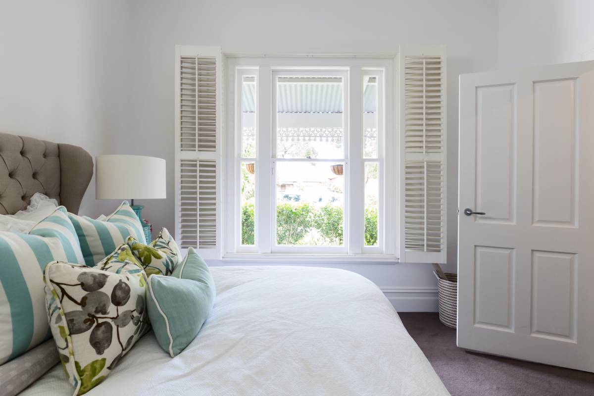 Wood interior shutters in a bedroom