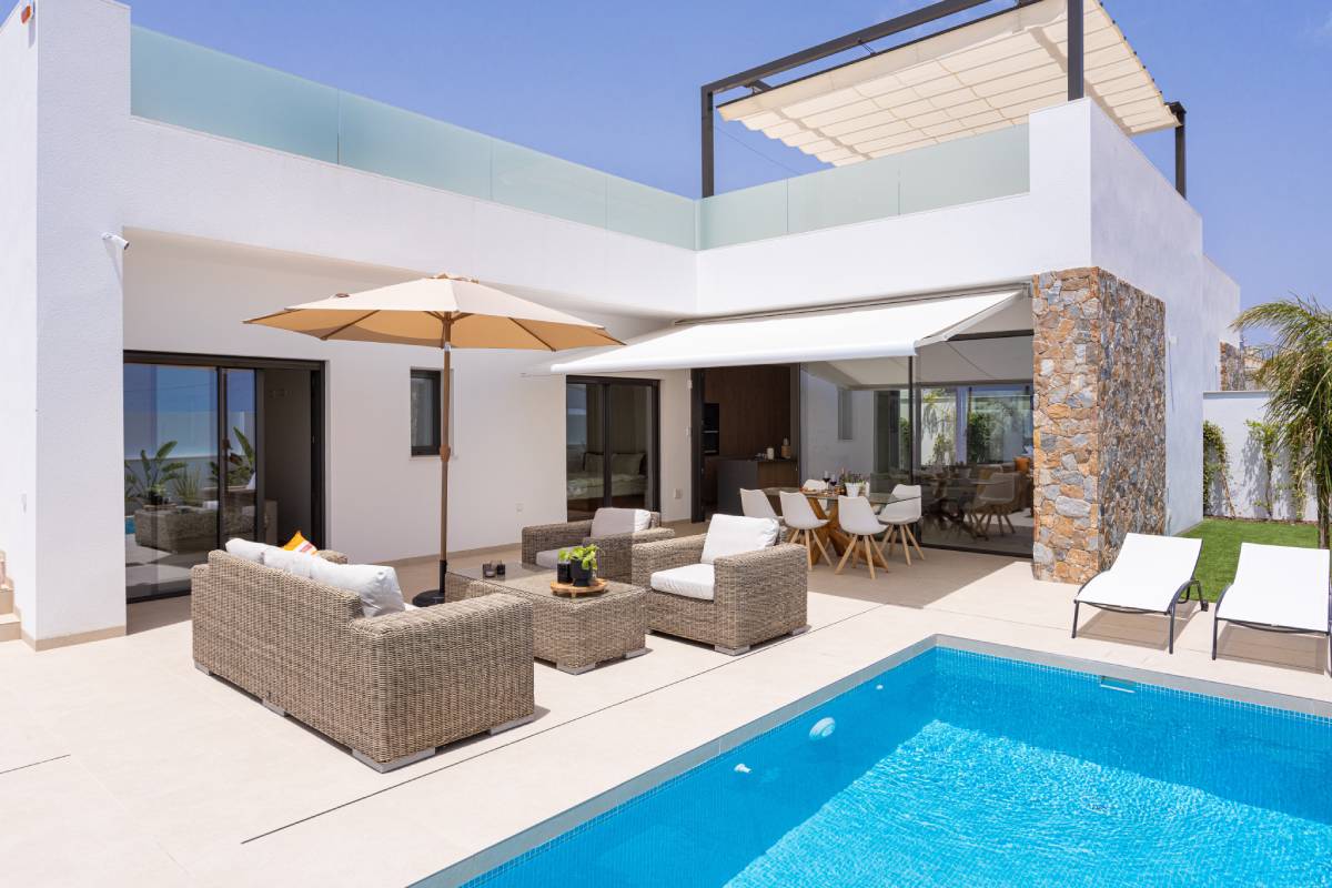 Modern villa terrace with pool, awning, and outdoor seating